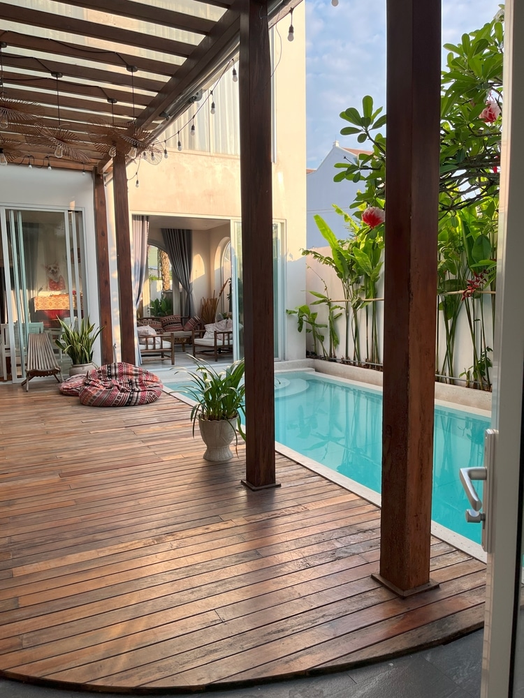 Aménagement terrasse bois avec piscine et pergola zen Terrasse en bois avec pergola au bord d'une piscine turquoise, jardin tropical et mobilier de jardin relaxant.